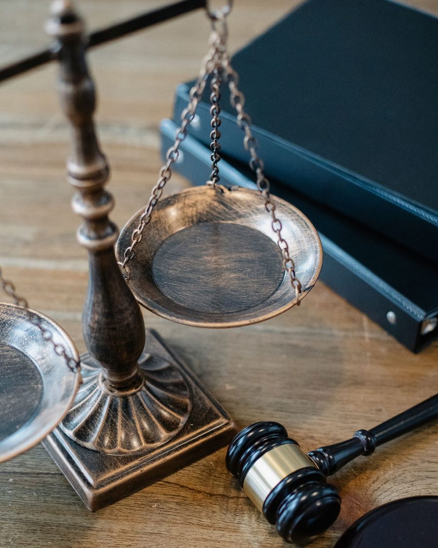 Balança da justiça sobre mesa de madeira - Datti & Rocha Advocacia